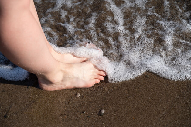 女孩漂亮女孩在水里行走的美腿赤脚休闲女人