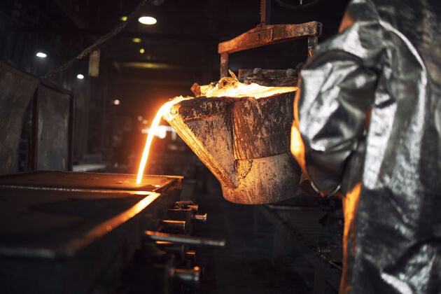 创始人一个不知名的铸造工人用热铁水填充铸造模具 钢铁生产和冶金熔融保护熔炉