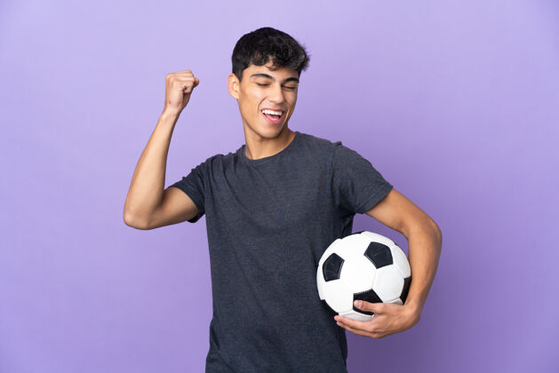 尖叫年轻的足球运动员越过孤立的紫墙庆祝胜利足球彩票球