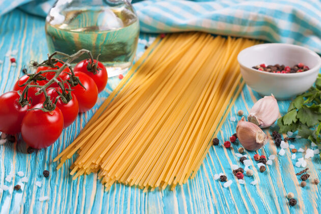 意大利意大利面 蓝色格子毛巾和蓝色木质表面的香料烹饪大蒜营养