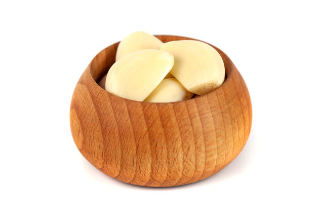 丁香蒜瓣放在木碗上 白色 健康的食物膳食配料切片