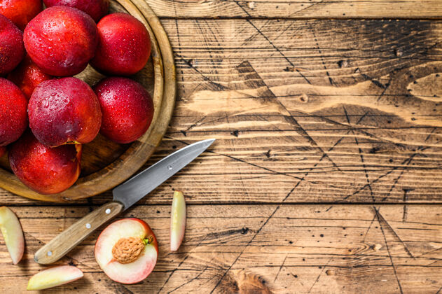 生的木制托盘上的红色油桃和半个油桃木背景.top查看.复制空间新鲜油桃食物