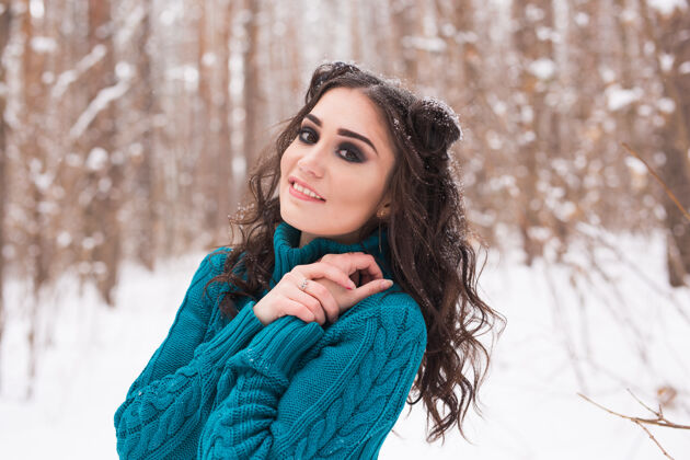 公园冬季 季节和人的概念-在雪地公园散步的年轻漂亮女人的特写肖像黑发户外树