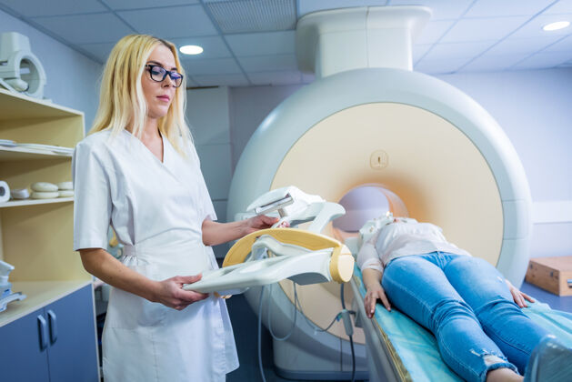 测试放射科医生为年轻女子做脑部核磁共振检查做准备女性科学技术