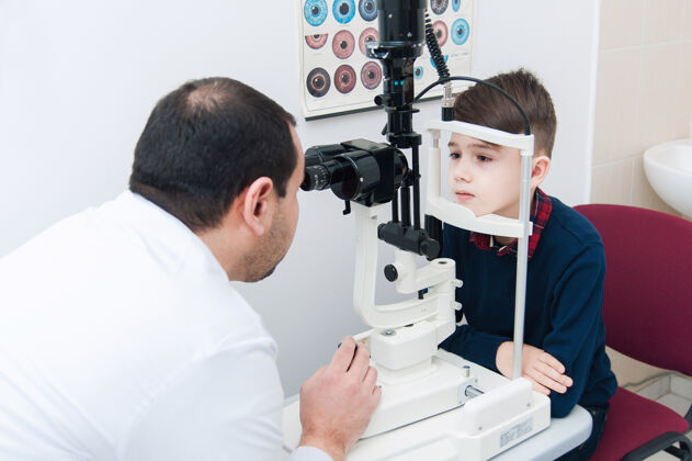 验光师孩子和妈妈一起做眼科检查室内父母验光