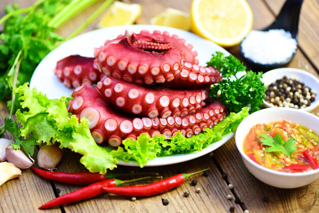 鱿鱼煮熟的章鱼触角与柠檬盘 章鱼食品熟沙拉海鲜鱿鱼乌贼盘子塔帕斯健康
