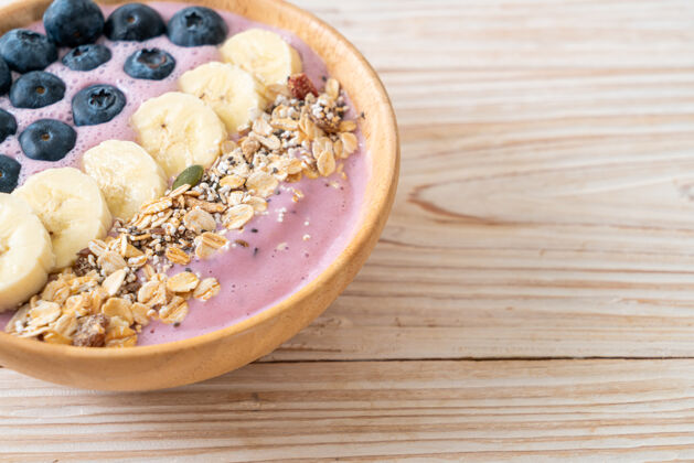 有机酸奶或酸奶冰沙碗配蓝莓 香蕉和牛奶健康麦片美食风格草莓紫色杏仁