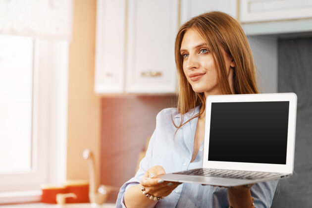 生活方式年轻女子站在厨房近距离展示笔记本电脑屏幕成年人笔记本电脑房子