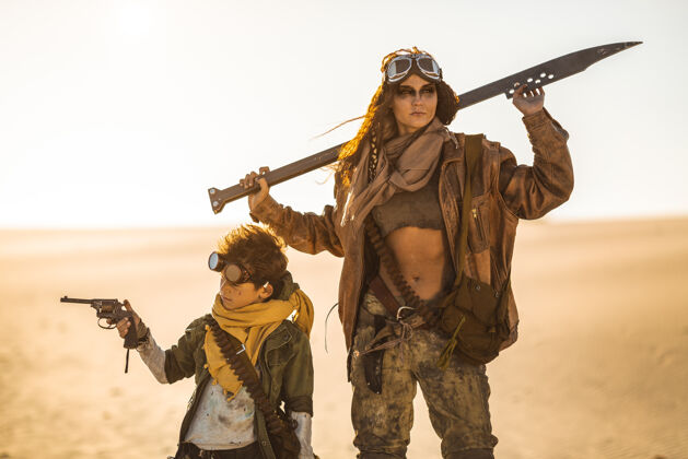 游戏带着武器的后世界末日的女人和男孩户外.沙漠背景是一片死寂姿势创意肮脏