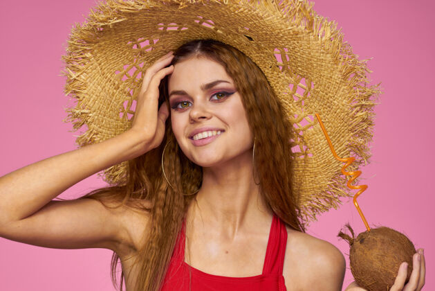 椰子戴着草帽的椰子鸡尾酒的女人 异国情调的夏日粉红比基尼酒精年轻