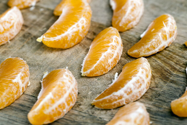 柑橘剥皮后切成片的橘子躺在一块旧的切割木板上 特写侧视图成熟水果有机