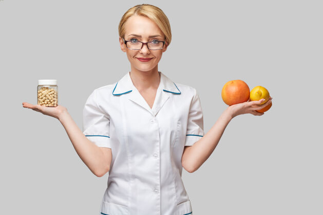 健康营养师医生健康的生活方式概念-持有新鲜的有机柑橘类水果-葡萄柚 橘子 柠檬和维生素胶囊罐健康水合作用补充