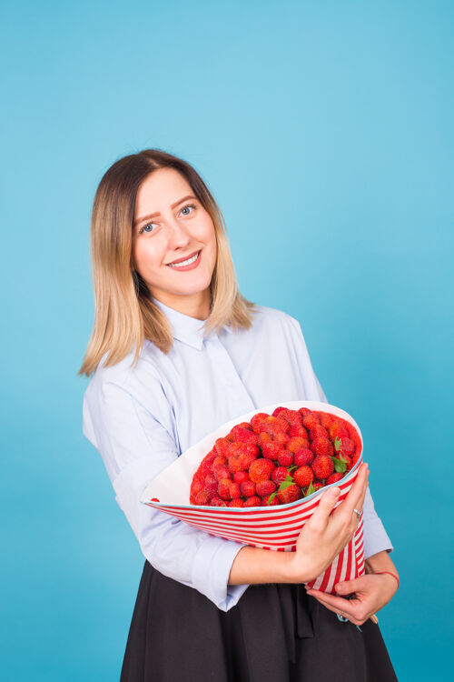 甜味拿着一束草莓的年轻女人草莓礼品素食