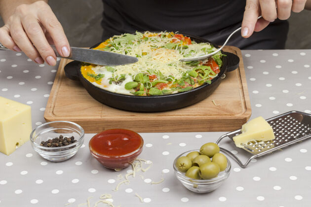 小吃炖鸡蛋和蔬菜泛指拿着叉子刀奶酪 烤架 橄榄 胡椒放在桌上奶酪食物准备生的