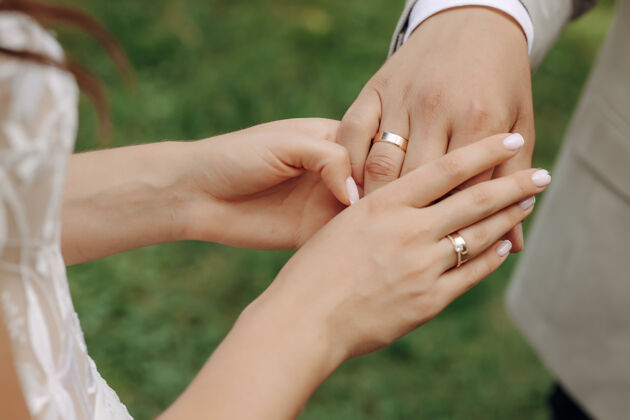 新娘新婚夫妇手上拿着结婚戒指和一场婚礼新婚夫妇的花束带着结婚戒指和结婚戒指婚礼戒指仪式