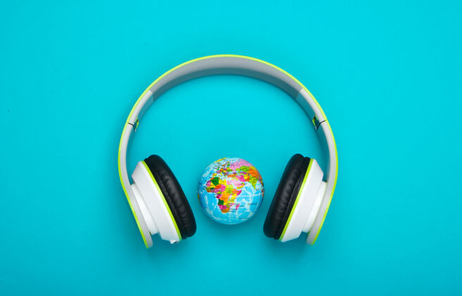 娱乐立体声耳机和蓝色表面的地球仪地球大陆生态