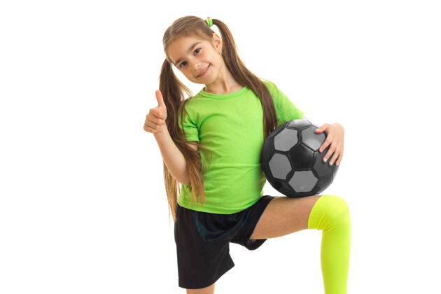 小拿着足球的快乐女人竖起大拇指 微笑着站在白色的地板上足球肖像足球