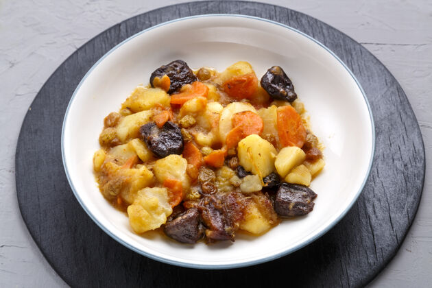干果犹太料理的菜是在混凝土表面的盘子里放上甜甜的椰枣和素食红萝卜蜂蜜炖自制