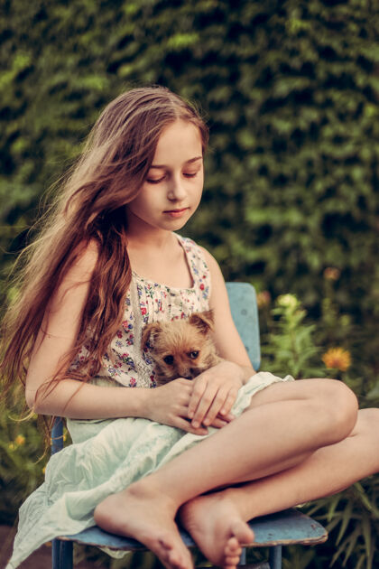 家庭一个金发小女孩带着她的宠物狗在外面停车场女孩喜欢一只小狗童年友谊孩子