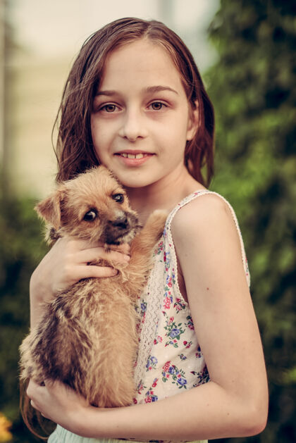 狗一个金发小女孩带着她的宠物狗在外面停车场女孩喜欢一只小狗动物友谊户外