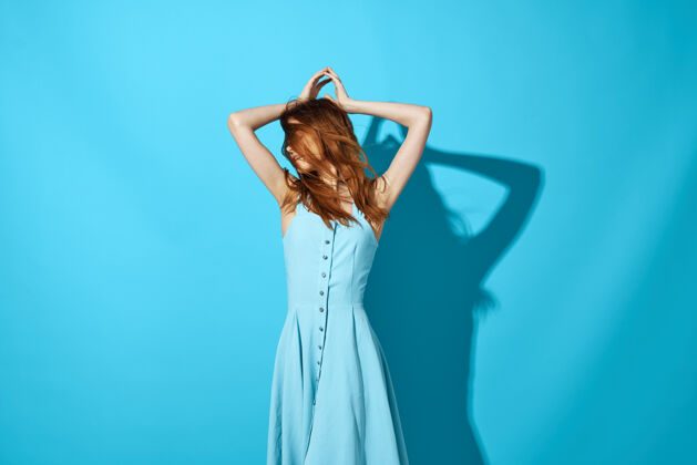 可爱开朗漂亮的女人抱着她的头发蓝色的豪华礼服上的影子休闲积极成人