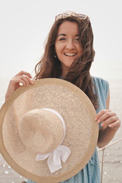 热带戴着夏帽的年轻女子在桥上摆姿势 假期快乐服饰女人风景