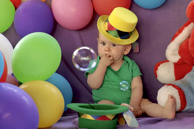 庆祝孩子坐在一个有趣的节日气氛与气球和看肥皂泡配件男孩肥皂泡