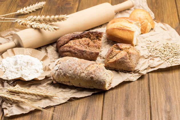 谷类面包片 擀面杖和纸上的麦穗面包面包餐