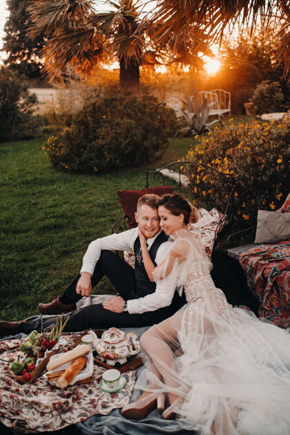 别墅在野餐会上给新婚夫妇吃晚饭一对夫妇在日落时分在公园里放松法国新娘去普罗旺斯野餐爱情两个乐趣
