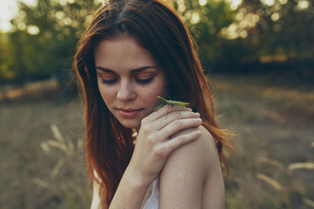 手美丽的女人在大自然中手持螳螂手指肖像昆虫