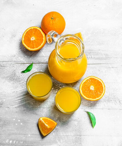 液体玻璃罐里的橙汁和新鲜的橙子柑橘橙子饮食
