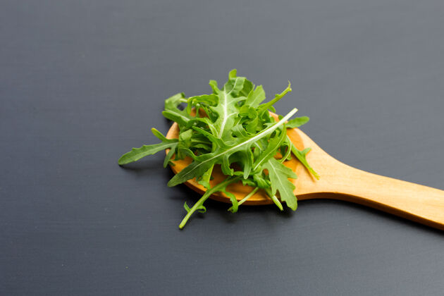 混合新鲜的绿色火箭沙拉在黑暗的表面上生菜堆芝麻菜