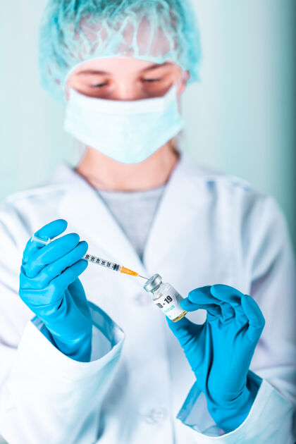 药物女医生或护士穿着制服 戴着手套 戴着口罩 在实验室里拿着带有冠状病毒疫苗标签的药瓶疫苗瓶医生大流行实验室