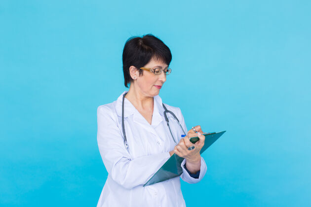 护理医生在蓝色背景上写处方 有复印空间诊所医生保健