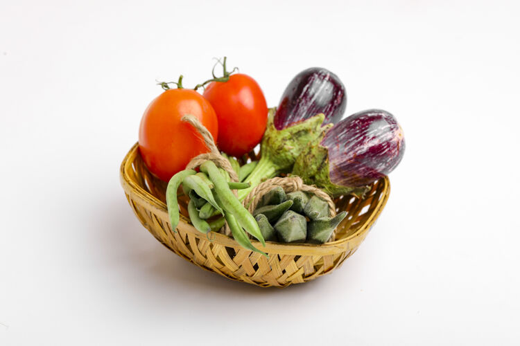营养把生蔬菜放在白色背景的木碗里搅拌西红柿沙拉柠檬