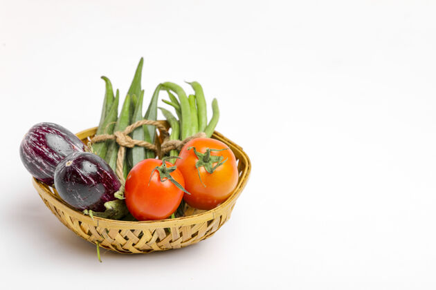 健康饮食把生蔬菜放在白色背景的木碗里搅拌蔬菜柠檬素食者
