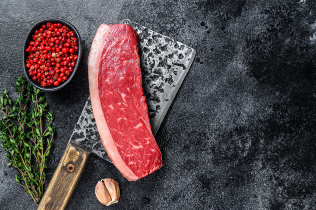 牛排生的盖臀牛肉牛排放在木制的切肉刀上桌面查看烤架屠宰红色