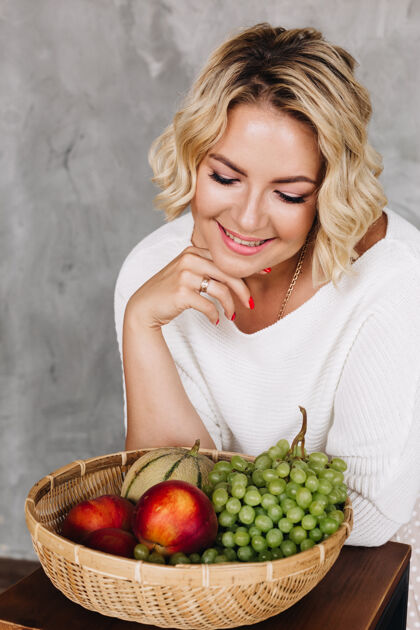 饮食年轻的金发女人选择健康的食物营养师微笑葡萄