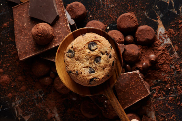 零食自制巧克力曲奇饼干放在木勺上 里面放着可可粉和糖果诱惑切片块