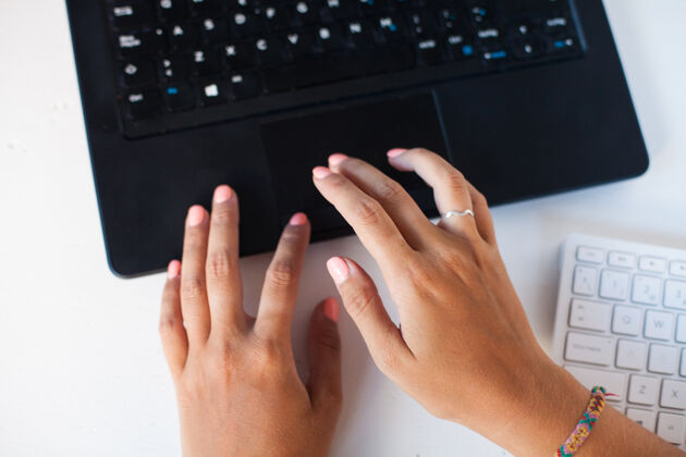 女性女性手在笔记本电脑键盘上打字作家办公桌笔记本电脑