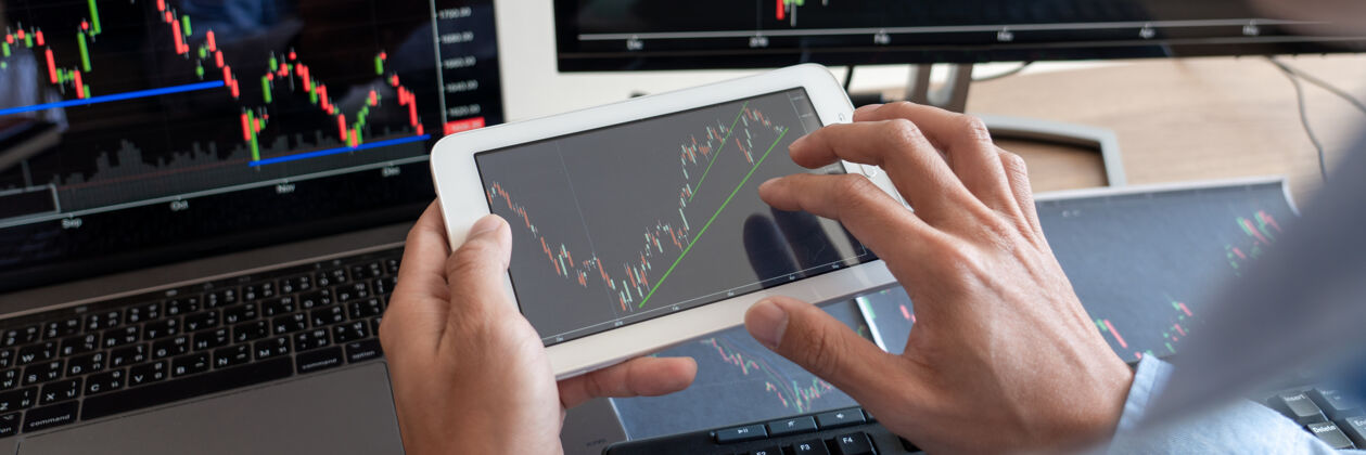 投资商人经纪人在屏幕上分析财务数据图表和报告平板电脑公司