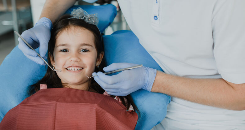 访问可爱的小女孩在接受儿科口腔医生的牙齿检查之前原发性牙痛诊所