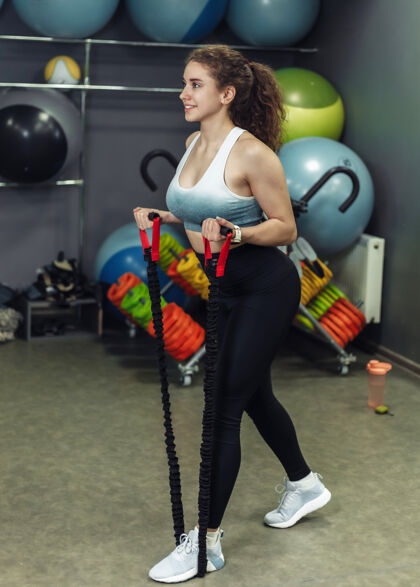 运动年轻健康的女人在训练课上用扩张器锻炼身体扩展物理课程