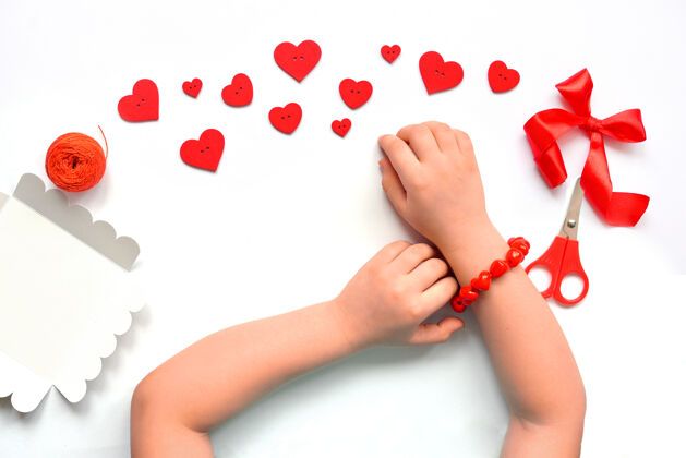 手工Diy手镯由红色心形珠子手工制作 为一个女孩在情人节的手上手指工匠技能