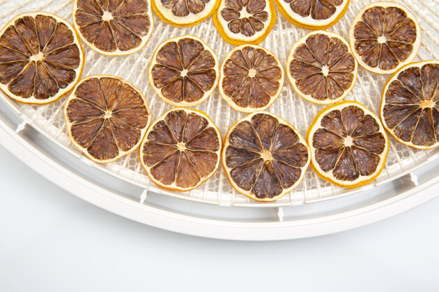 果皮在一个塑料干燥托盘上的干柑橘水果片干燥柠檬营养