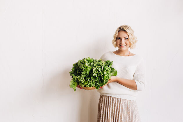 营养师年轻的金发女人选择健康的食物女人蔬菜微笑