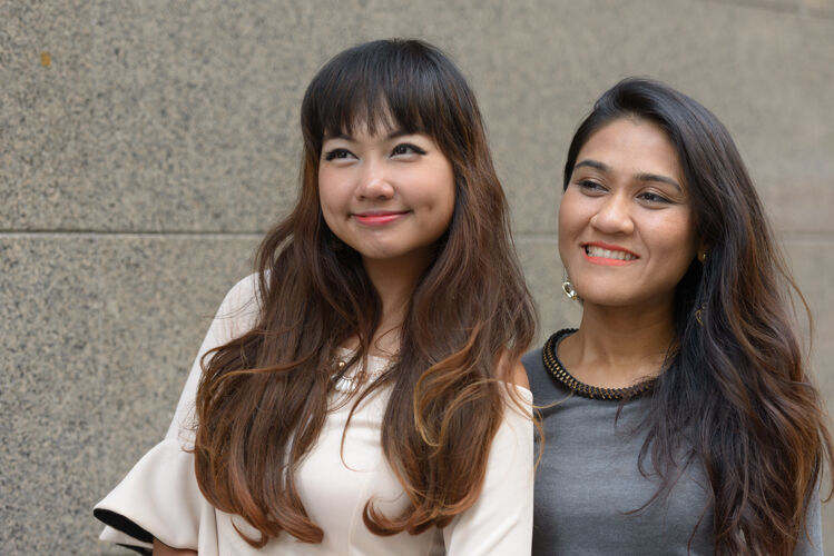 女性两位年轻的亚洲女商人在城市户外的合影友谊思考夫妇