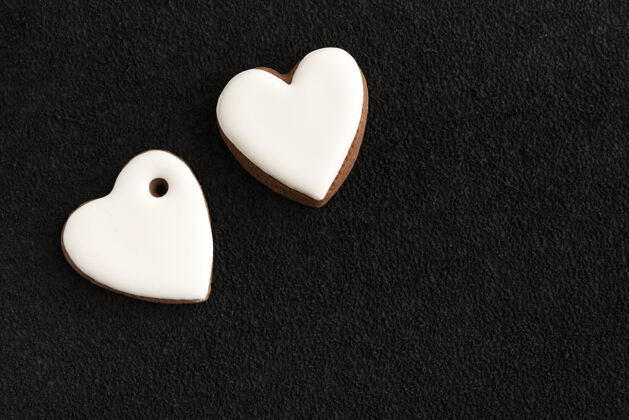 传统两个白色心形姜饼和一个黑色的背景.copy空间装饰浪漫情人节