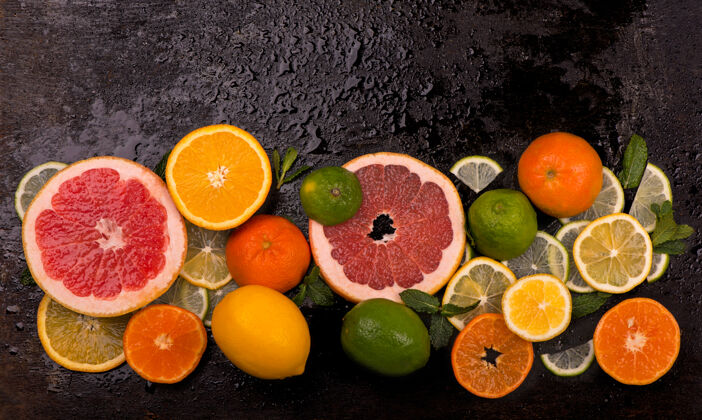 食物柑橘背景新鲜柑橘类水果-柠檬 橙子 酸橙 柚子在木制背景上半维生素切片