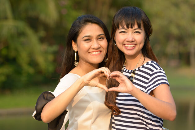 心两位亚洲年轻女性在公园户外放松的写真公园朋友和平